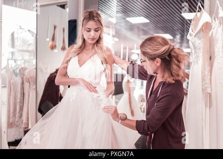 Belle femme agréable à la recherche à la robe de mariage Banque D'Images