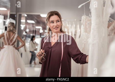 Femme agréable à la designer à la robe de mariage Banque D'Images