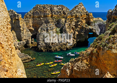 Les kayakistes dans la formation rocheuse au Camilo Plage, Praia do Camilo, Lagos, Algarve, Portugal Banque D'Images