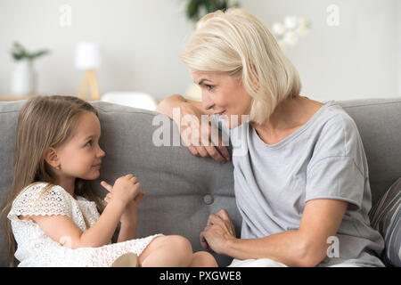 Grand-mère et petite-fille mignon vous détendre sur parler de la table Banque D'Images