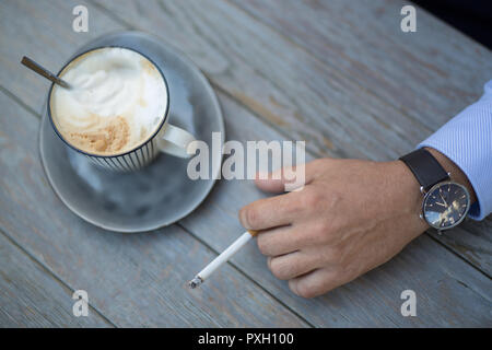 Libre tourné d'une tasse de café et un homme part avec un jour de cigarettes Banque D'Images