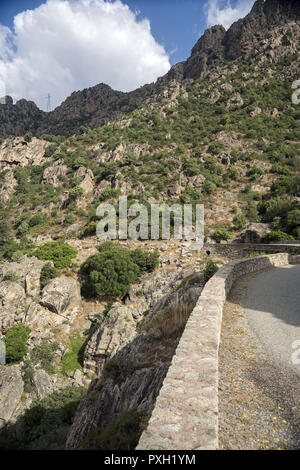 Entre la vallée et les pentes rocheuses abruptes, une route sinueuse de montagne en Corse. Tal zwischen steilen, felsigen kurvenreichen und Hängen Bergstraße. Banque D'Images