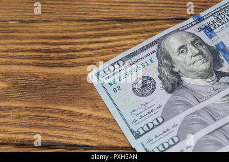 Plusieurs nouveaux projets de cent dollars se situent sur une texture en bois table en diagonale. Banque D'Images