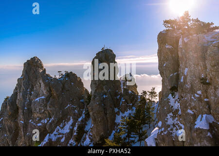 Série horizontale des sommets de montagne, la lumière du soleil à travers un pin rétroéclairé, nuages dans le ciel bleu, l'arrière-plan, les montagnes sombres Banque D'Images