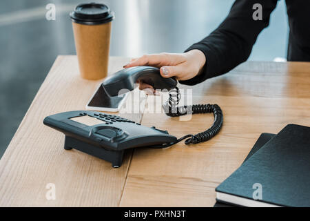 Portrait of businesswoman prenant combiné du téléphone fixe dans office Banque D'Images