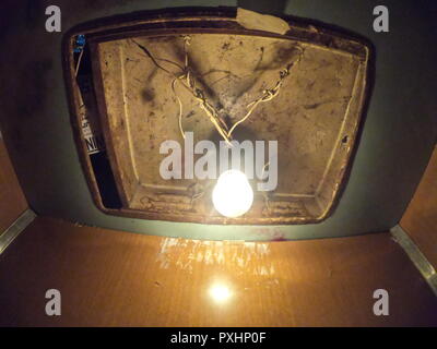 Vieille Ampoule électrique suspendue sur le fil dans l'ascenseur Banque D'Images