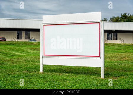 Coup horizontal d'un grand panneau blanc en blanc avec une bordure rouge dans un emplacement commercial. Banque D'Images