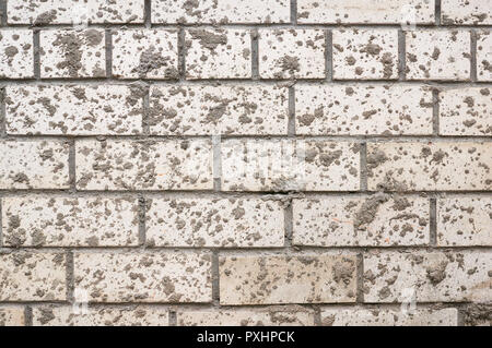 Mur de brique de boue blanc taché d'éclaboussures. Banque D'Images