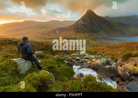 Une montagne walker prendre dans le magnifique paysage de l'Ogwen Valley et le pic de la montagne Tryfan dans le Nord du Pays de Galles, Royaume-Uni Banque D'Images