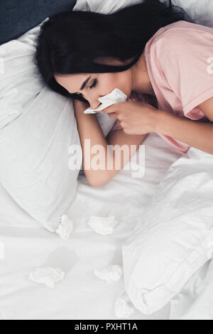 Portrait de jeune femme malade avec le nez dans mon lit avec des serviettes Banque D'Images