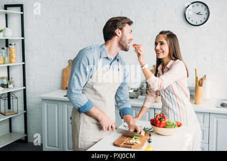 Copain copine et couper des légumes à la tomate le nourrir dans la cuisine Banque D'Images