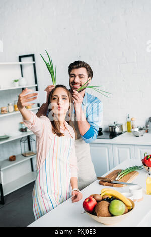 Couple qui, tout en s'amusant selfies lors de la cuisson dans la cuisine Banque D'Images