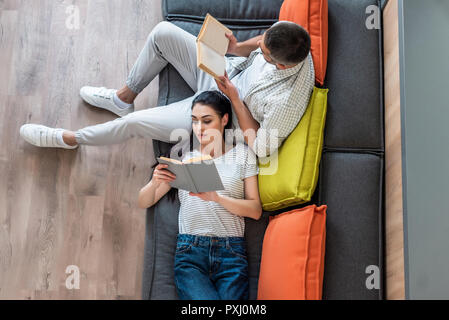 Vue de dessus de couple reading books sur la table à la maison Banque D'Images