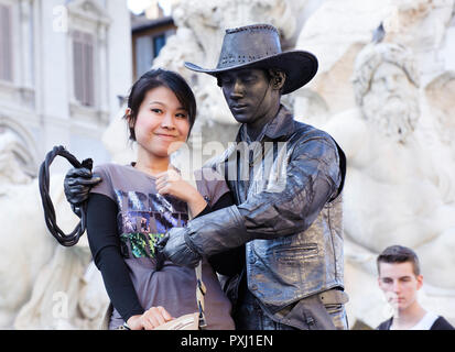 Musicien ambulant vêtu comme un cowboy avec une jeune touriste, Piazza Navona, Rome, Italie. Banque D'Images