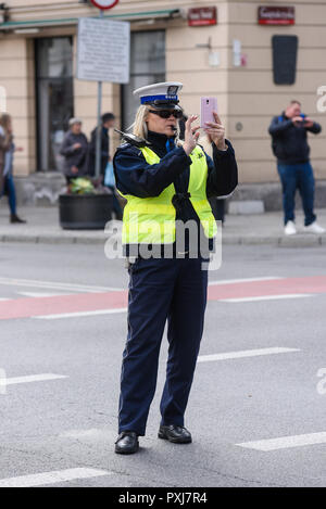 Varsovie / Pologne - Octobre.02,2018 : Police woman standing on the cross road et contrôler le trafic. Vêtu d'un uniforme de la police avec du jaune à l'ouest. Banque D'Images
