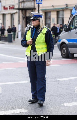 Varsovie / Pologne - Octobre.02,2018 : Police woman standing on the cross road et contrôler le trafic. Vêtu d'un uniforme de la police avec du jaune à l'ouest. Banque D'Images