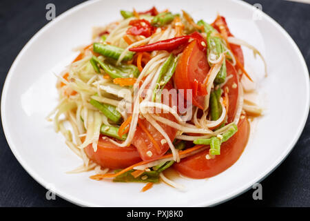 La nourriture épicée thaï, salade de papaye (Som Tam ou en thaï) avec piment, tomate, haricot long mélangé avec la sauce Thaï et d'ingrédients. Banque D'Images