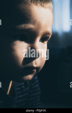 Portrait d'un enfant en regardant la télévision dans une faible lumière Banque D'Images