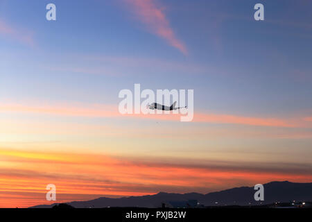 Avion de décoller à LAX voler dans le ciel crépusculaire de Californie du sud Banque D'Images