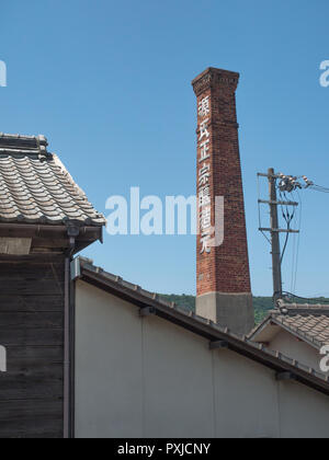 Nom brasserie, ancienne cheminée d'usine en brique désaffecté, kanji inscription, poteau électrique, toits de tuile, Takamatsu, Kagawa, Japon Banque D'Images