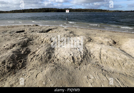 Waren, Allemagne. 22 octobre, 2018. Le lieu de baignade Ecktannen an der Müritz est sec, un panneau pour avertir les non-nageurs est presque à sec elle-même. La sécheresse prolongée a entraîné des niveaux d'eau dans les lacs du Mecklembourg à chuter de près de 70 centimètres. La situation n'est pas encore une menace pour les grands lacs. Dans les petits lacs et rivières, d'autre part, les poissons peuvent mourir dans l'hiver s'il y a un couvert de glace. Crédit : Bernd Wüstneck/dpa/Alamy Live News Banque D'Images