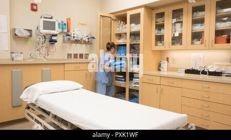 Une infirmière de salle d'urgence de l'hôpital en stock d'une armoire avec un traumatisme de fournitures. Banque D'Images