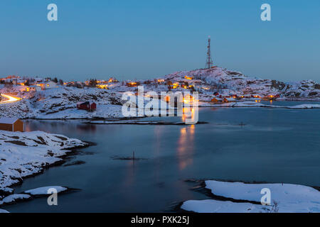 Les maisons autour de Sorvagen et Tind s'allumer les collines enneigées de l'île Moskenesoya comme la nuit tombe sur les îles Lofoten, Norvège Banque D'Images