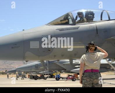 Oregon Air National Guard Senior Airman Aimee Lonidier, chef d'équipe avec la 142e Escadre de chasse Groupe Maintenance salue le capitaine Jamie Hastings, 123e Escadron de chasse, alors qu'il commence un vol d'après-midi avec un F-15 Eagle soutenant le cours d'instructeur d'armes à Nellis Air Force Base, Nevada, le 1 juin 2017. Banque D'Images