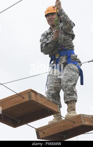 Un Guardsman avec la Garde nationale de l'Alaska du Programme de soutien de la recruter ensemble traverse suspendue tout en confiance high ropes courses au Camp Carroll, Joint Base Elmendorf-Richardson, Alaska, le 4 juin 2017. La mission de la RSP est d'offrir du soutien, de la formation et du mentorat aux nouveaux soldats et aider à leur introduction et la formation. Banque D'Images