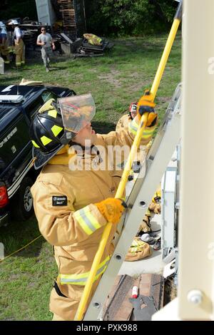 Le s.. Hector Zamora, 125e Escadron de génie civil, d'une échelle échelles de pompier avec perche dans la main, pour un second étage fenêtre pendant la formation au Naval Air Station Jacksonville, en Floride, le 2 juin 2017. En sachant comment transporter et soulever une échelle est essentielle à une compétence de pompier. Banque D'Images