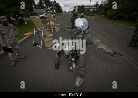 Les cadres supérieurs de l'US Air Force Airman Kimberly Moncayo, un perchman avec la 108e Escadre, est traitée par l'équipage de l'aire de contrôle de la contamination au cours d'un exercice à Joint Base McGuire-Dix-Lakehurst, N.J., le 7 juin 2017. Banque D'Images