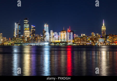 New York, États-Unis, 21 octobre 2018. Les lumières de Manhattan de la ville se reflètent sur le fleuve Hudson dans cette photo prise de nuit depuis le New Jersey. Pho Banque D'Images