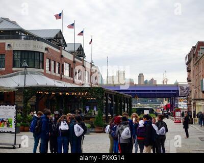 Des groupes d'étudiants adolescents, debout devant des commerces, sur un voyage à South Street Seaport District, Manhattan, New York, NY, USA. Banque D'Images