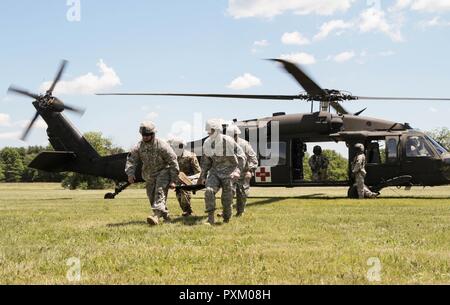 Les soldats avec 108e Compagnie médicale de soutien de secteur, 213e groupe d'appui régional, New Jersey Army National Guard, off-chargement d'une victime simulée d'un UH-60 Black Hawk exploités par des soldats du détachement 2, la Compagnie Charlie, 2e Escadron, le 104e Régiment, 28e Brigade d'aviation de combat, Texas Army National Guard au cours de formation annuel à Fort Indiantown Gap le 9 juin 2017. Banque D'Images