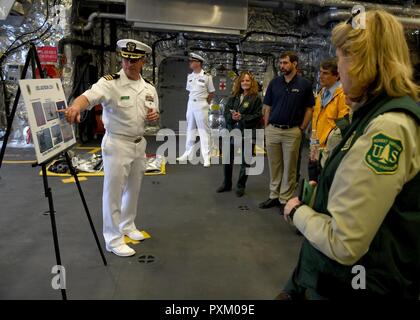 PORTLAND (Orégon, 9 juin 2017) Le Cmdr. David W. Walton Jr., directeur général de USS Jackson (LCS 6), effectue une visite de son navire pour les membres du Bureau de gestion des terres, Forestry Service des États-Unis, l'Environmental Protection Agency, et U.S. Fish and Wildlife, au cours d'une agence partenaire de l'événement de sensibilisation à Portland, Ore., pendant la semaine de festival de Rose. Le festival de Portland et la Fleet Week sont une célébration de la mer avec des services marins, marines, et les membres de la Garde côtière des États-Unis et du Canada faisant de la ville un port d'escale. Banque D'Images