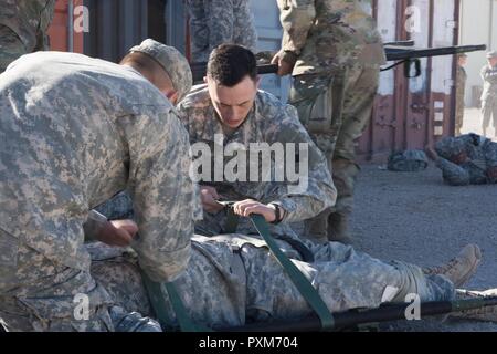 La CPS. Jared Cooper, avec la 96e Brigade, sangles de maintien en puissance d'un accident fictif dans une civière durant un événement de formation un grand nombre de blessés au combat Gareautrain Cours à Ogden, Utah, le 11 juin 2017. Le cours de 40 heures couvre les soins initiaux pour lutter contre les blessures et qui demande l'évacuation médicale. Banque D'Images