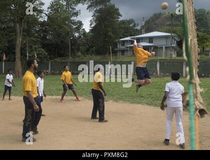 GALLE, Sri Lanka (14 juin 2017) marins affectés à la classe Ticonderoga croiseur lance-missiles USS Lake Erie (CG 70) jouer un match de football avec les enfants de l'école. Nawodya Mallika Le lac Érié est au Sri Lanka pour soutenir les opérations d'aide humanitaire à la suite de graves inondations et glissements de terrain qui ont dévasté de nombreuses régions du pays. De fortes pluies récentes portées par une mousson de sud-ouest provoqué inondations et glissements de terrain dans tout le pays, le déplacement de milliers de personnes et causant des dommages importants aux habitations et bâtiments. Banque D'Images