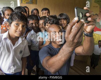 GALLE, Sri Lanka (14 juin 2017) Le capitaine Lex Walker, commodore, sept destroyers prend des photos avec les élèves de l'École de Nawodya Mallika près de Galle, Sri Lanka, 14 juin lors d'un événement d'engagement communautaire à l'appui des opérations d'assistance humanitaire à la suite de graves inondations et glissements de terrain qui ont dévasté de nombreuses régions du pays. De fortes pluies récentes portées par une mousson du sud-ouest a déclenché des inondations et des glissements de terrain dans tout le pays, le déplacement de milliers de personnes et causant des dommages importants aux habitations et bâtiments. Banque D'Images