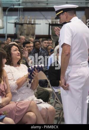 La NORFOLK (8 juin 2017) Le lieutenant Cmdr. Gregory Curl présente olde' gloire à sa femme, Christina Curl, lors de sa cérémonie de retraite au Centre de formation technique de l'aviation navale Naval Station Norfolk sur l'unité. Dernière Curl a servi comme agent de manutention de l'avion à bord du porte-avions USS George Washington (CVN 73). Banque D'Images