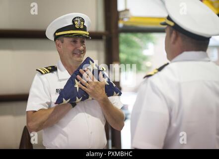 La NORFOLK (8 juin 2017) Le lieutenant Cmdr. Gregory Curl salue avec un drapeau au cours de sa retraite au Centre de formation technique de l'aviation navale Naval Station Norfolk sur l'unité. Dernière Curl a servi comme agent de manutention de l'avion à bord du porte-avions USS George Washington (CVN 73). Banque D'Images