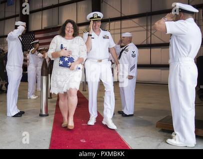 La NORFOLK (8 juin 2017) Le lieutenant Cmdr. Gregory Curl et son épouse Christina Curl à pied à travers les garçons de conclure sa retraite cérémonie au Centre de formation technique de l'aviation navale Naval Station Norfolk sur l'unité. Dernière Curl a servi comme agent de manutention de l'avion à bord du porte-avions USS George Washington (CVN 73). Banque D'Images