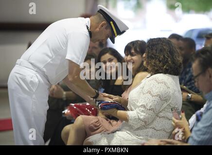 La NORFOLK (8 juin 2017) - Le Lieutenant Cmdr. Gregory Curl donne sa femme, Christina Curl, Olde' gloire au cours de sa retraite au Centre de formation technique de l'aviation navale Naval Station Norfolk sur l'unité. Dernière Curl a servi comme agent de manutention de l'avion à bord du porte-avions USS George Washington (CVN 73). Banque D'Images