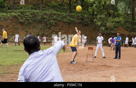 KALUTARA, Sri Lanka (15 juin 2017) Le capitaine Darren McPherson, commandant de la classe Ticonderoga croiseur lance-missiles USS Lake Erie (CG 70), joue le cricket avec les élèves de l'école près de Kalutara-Molkawa Kalutara, Sri Lanka, le 15 juin lors d'un événement d'engagement communautaire à l'appui des opérations d'assistance humanitaire à la suite de graves inondations et glissements de terrain qui ont dévasté de nombreuses régions du pays. De fortes pluies récentes portées par une mousson du sud-ouest a déclenché des inondations et des glissements de terrain dans tout le pays, le déplacement de milliers de personnes et causant des dommages importants à h Banque D'Images