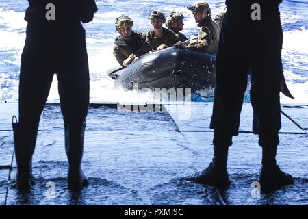 Marines avec la 31e unité expéditionnaire maritime amphibie du peloton de reconnaissance (ARP), faire de la lutte contre le maraudage en caoutchouc classique (CCRR), l'approche du bien pont de l'USS Bonhomme Richard (DG 6) pendant la formation helocast, 15 juin 2017. Maître de la marine s'accouple travaillent ensemble pour assurer la salubrité de l'ARP avec récupération des Marines effectuant des opérations amphibies et de formation. Helocast est une spécialité de la 31e MEU'S ARP. Au cours d'un helocast, le CCRR est lancé à partir de l'arrière d'un aéronef à voilure tournante, suivie de Marines qui sautent de l'avion et le CCRR conseil d'effectuer des missions de reconnaissance amphibie. Banque D'Images