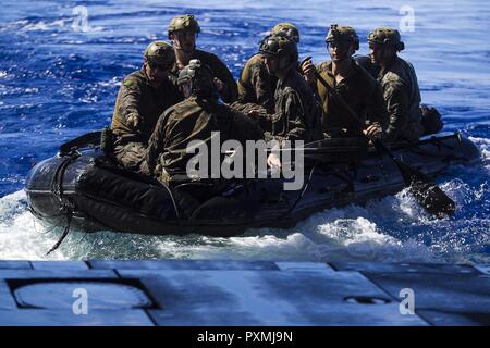 Marines avec la 31e unité expéditionnaire maritime amphibie du peloton de reconnaissance (ARP), faire de la lutte contre le maraudage en caoutchouc classique (CCRR), l'approche du bien pont de l'USS Bonhomme Richard (DG 6) pendant la formation helocast, 15 juin 2017. Maître de la marine s'accouple travaillent ensemble pour assurer la salubrité de l'ARP avec récupération des Marines effectuant des opérations amphibies et de formation. Helocast est une spécialité de la 31e MEU'S ARP. Au cours d'un helocast, le CCRR est lancé à partir de l'arrière d'un aéronef à voilure tournante, suivie de Marines qui sautent de l'avion et le CCRR conseil d'effectuer des missions de reconnaissance amphibie. Banque D'Images