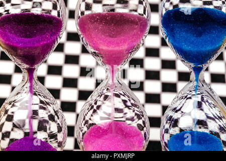 Hourglass colorés sur le fond de la paroi d'échecs Banque D'Images