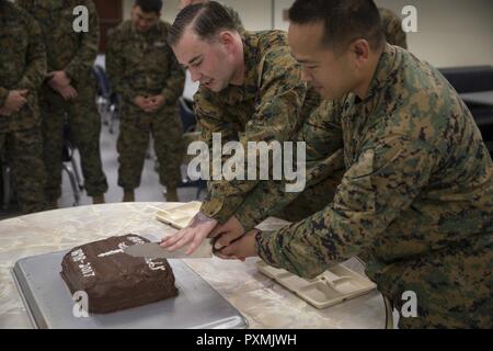 L'hôpital (chef Corpsman Fleet Marine Force) Edgar E. Cuenca, à droite, un technicien en médecine préventive avec élément de commandement, III Marine Expeditionary Force, et de l'hôpital Corpsman (FMF) Joseph E. Clack, gauche, un affecté au 3ème corpsman, 3e Bataillon Médical de la logistique maritime, Groupe III MEF, simultanément découper un gâteau de cérémonie lors d'une fête pour le 119e anniversaire de l'hôpital au Camp taux corpsman Mujuk, Pohang, République de Corée, le 17 juin 2017. Des marines de la Compagnie Bravo, 3e Bataillon, de l'application de la Loi maritime du Groupe III de l'Administration centrale, III MEF et Corpsmen avec 3e, 3e Bn Med, MLG III M Banque D'Images