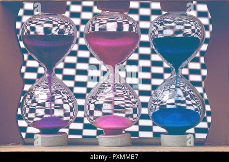 Hourglass colorés sur le fond de la paroi d'échecs, tonique libre Banque D'Images
