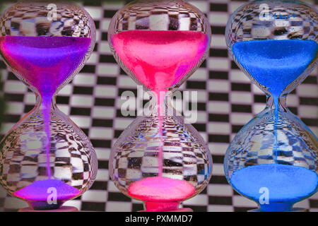 Hourglass colorés sur le fond de la paroi d'échecs Banque D'Images