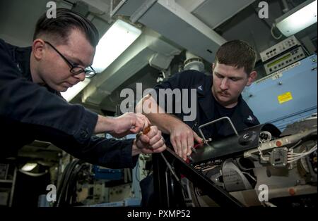 Mer Méditerranée (18 juin 2017) Technicien en électronique de l'Aviation 3e classe Kevin Beales, droite, et technicien en électronique de l'Aviation 2e classe Cody peu de travail sur la voie à suivre (FLIR) unité à bord du porte-avions USS George H. W. Bush (CVN 77) (GHWB). GHWB, une partie de la George H. W. Groupe aéronaval du Bush (GHWBCSG), mène des opérations navales dans la sixième flotte américaine zone d'opérations à l'appui de la sécurité nationale des États-Unis en Europe et en Afrique. Banque D'Images